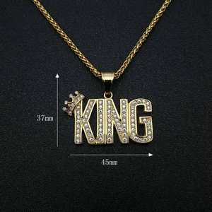 Detailed view of gold plated KING pendant with crown and rhinestones, size 37mm x 45mm