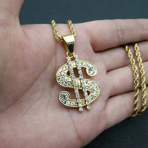 Detailed close-up of gold-plated iced out dollar sign pendant with rope chain necklace