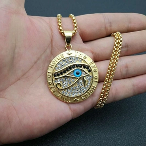 Collier avec pendentif Œil d'Horus en acier inoxydable doré et cristaux brillants