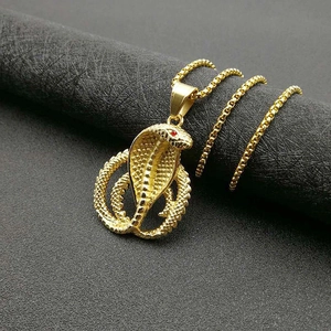 Collier cobra en acier inoxydable doré avec yeux en cristal rouge sur fond noir
