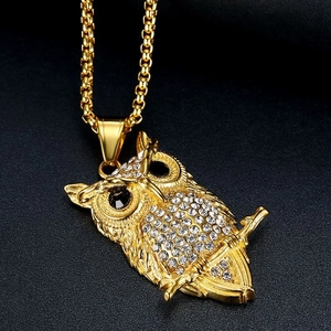 Macro-opname van een vergulde hiphop uil ketting met witte strass steentjes en edelstenen