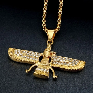 Detailed close-up of golden Faravahar pendant featuring sparkling crystals on black surface