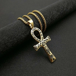 Collana con chiave Ankh egizia dorata con geroglifici neri su sfondo scuro testurizzato
