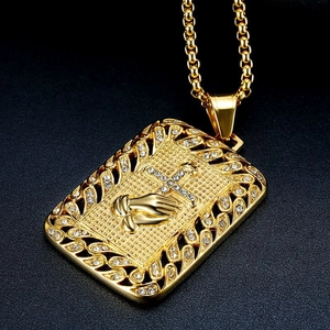 Détail du pendentif mains en prière en acier doré avec croix sertie de cristaux