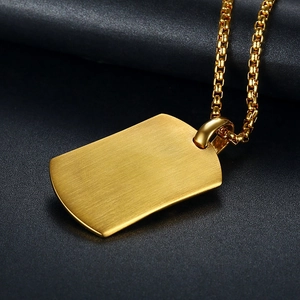 Close-up of gold plated dog tag pendant with brushed texture and box chain