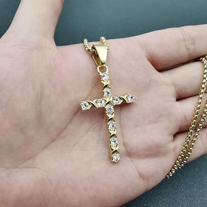 Nahaufnahme des vergoldeten Hip-Hop-Kreuzanhängers mit Zirkonia an einer Kugelkette