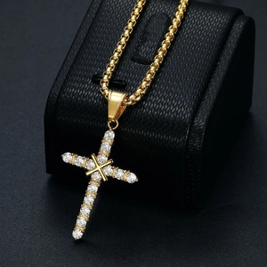 Iced out gold cross pendant necklace with clear zircon stones on a black leather display
