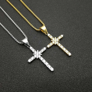 Detailed view of gold and silver cross pendants with shimmering zircon stones on box chains
