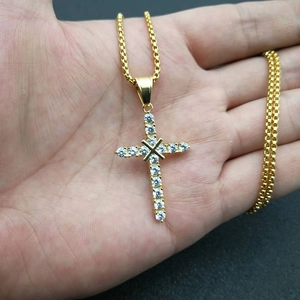 Close-up of a gold-plated titanium steel cross pendant necklace with sparkling cubic zirconia