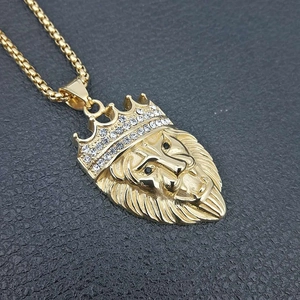 Goldene Löwenkopf Halskette mit Krone und weißen Kristallen auf schwarzem Lederhintergrund