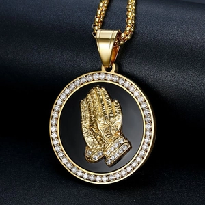 Gros plan du pendentif hip hop plaqué or avec zircons et mains en prière