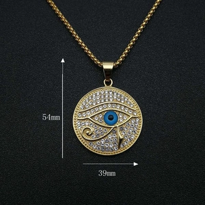 Nahaufnahme des vergoldeten Horusauge-Anhängers mit blauem Stein und Strass-Besatz
