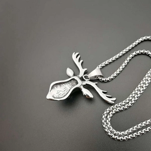 Collier pendentif tête d'élan en acier titane style punk rétro sur un fond gris neutre