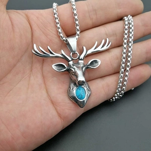 Pendentif tête d'élan vintage avec turquoise bleue sur une chaîne à billes argentée