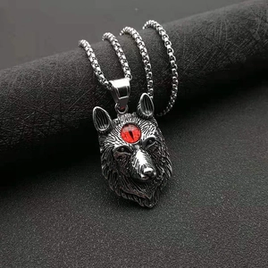 Gros plan du pendentif tête de loup viking montrant les détails des poils et l'œil rouge