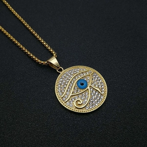 Detaillierte Makroansicht des goldenen Horus-Auge-Anhängers mit Strass und blauem Auge