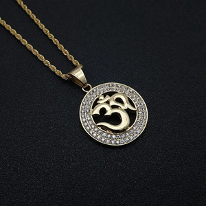 Detailed close-up of golden Om pendant with sparkling rhinestones on rope chain