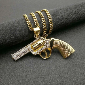 Hip-Hop-Halskette mit vergoldetem Revolver-Anhänger und funkelnden Strasssteinen auf einer Panzerkette