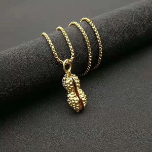 Hip hop style gold vacuum plated peanut pendant necklace with texture on a display stand