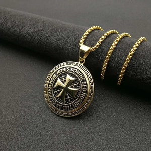 Détail du pendentif Templier doré avec inscription latine sur une chaîne gourmette