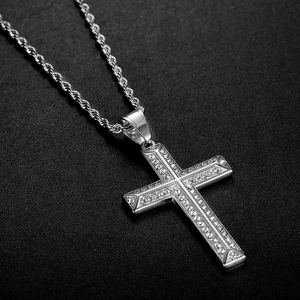 Pendentif croix en acier titane argenté avec diamants blancs sur fond de cuir noir texturé