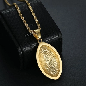 Detail van gouden rugbyhanger met korrelige textuur en gepolijste randen aan een touwketting