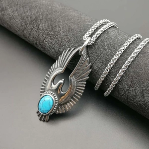 Macro detail of retro eagle pendant with turquoise stone on heavy braided chain