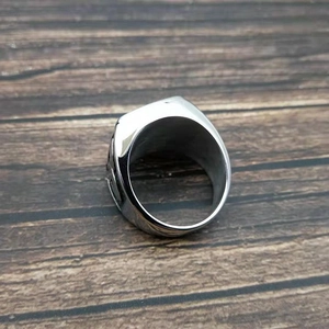 Detailed macro view of silver Celtic knot pattern on a wide stainless steel band ring