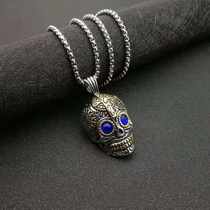 Collier crâne punk rétro avec yeux en pierres bleues et croix dorée sur pendentif argent