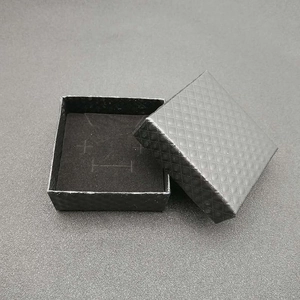 Close-up of square black jewelry gift box with textured finish and velvet lining inside