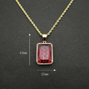 Vue macro du pendentif hip hop doré avec gemme rouge rectangulaire, taille 43mm x 22mm