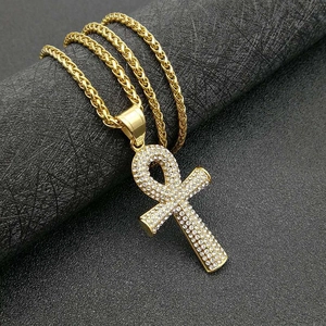 Collier clé Ankh égyptienne dorée avec strass sur un fond noir texturé élégant