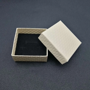 Macro view of cream-colored square jewelry gift box with textured diamond pattern