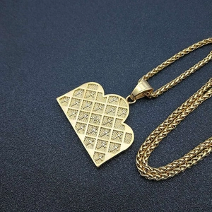Collier hip hop avec pendentif cœur plaqué or et texture quadrillée sur fond noir