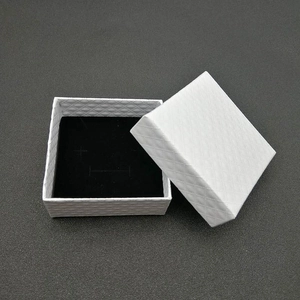Close-up of white textured faux leather jewelry box with black flocked foam insert