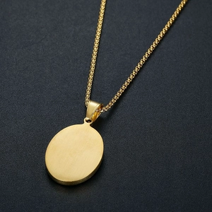 Vue détaillée d'un pendentif ovale plaqué or avec texture brossée et chaîne à mailles