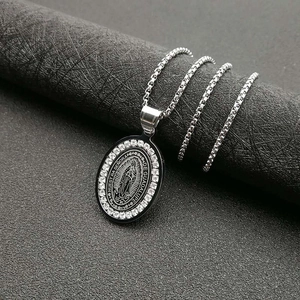 Gros plan du pendentif Vierge Marie Guadalupe orné de strass sur fond de texture noire