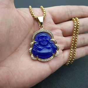 Detailed shot of gold-plated Buddha pendant with blue resin and pavé crystals on hand