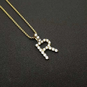Detailed macro view of gold-plated letter R pendant with AAA zircon micro-inlay