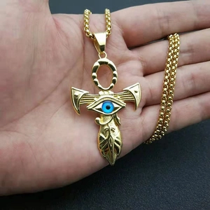 Golden Ankh cross necklace with blue evil eye pendant held in hand for men and women