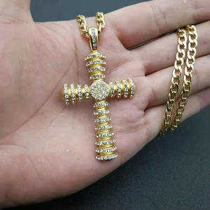 Golden iced out cross pendant with cubic zirconia on a thick curb chain necklace