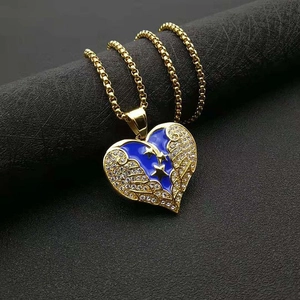 Détail du pendentif cœur doré avec émail bleu, étoiles et ailes en strass brillant