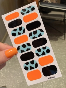 Detail of LT-019 nail wraps with orange, black, and blue cow print designs for DIY manicure