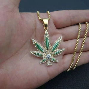 Dettaglio del ciondolo a foglia d'acero hip-hop dorato con smalto verde e cristalli bianchi
