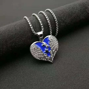 Détail macro du pendentif coeur en émail bleu avec ailes en strass et étoile