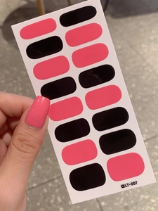 Close-up of black and pink self-adhesive nail art stickers on a white backing card