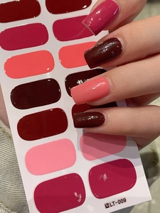 Detailed view of glossy red adhesive nail wraps in various shades of wine and pink
