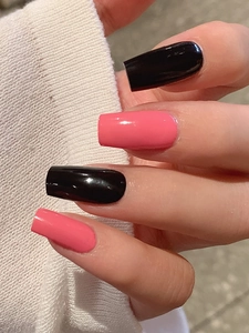 Close-up of glossy black and pink square press-on nails on model's hand with white cuff