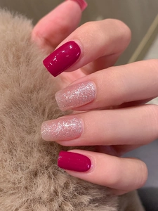 Close-up of rose red and silver glitter self-adhesive nail stickers on long oval nails