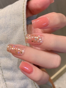 Detailed view of coral pink gradient nail stickers with gold foil and glitter finish